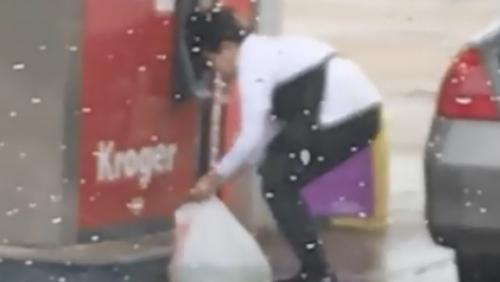 Une femme remplit un sac en plastique avec de l'essence aux USA